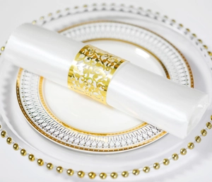 Detailansicht der goldfarbenen Serviettenschnalle mit aufwendigem Laser-Cut-Rankenmuster