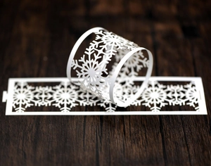 Laser-cut white snowflake paper napkin rings for elegant Christmas dinner table decor