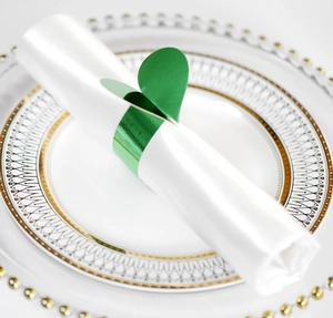 Gros plan du rond de serviette coeur vert sur satin blanc pour décor de table