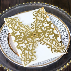 Detail of laser-cut rose gold wedding invitation with elegant floral hollow patterns