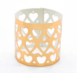 Detail of rose gold napkin ring featuring hollowed heart patterns and polished finish