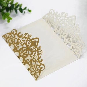 Close-up of laser-cut rose gold wedding invitation with elegant floral hollow pattern