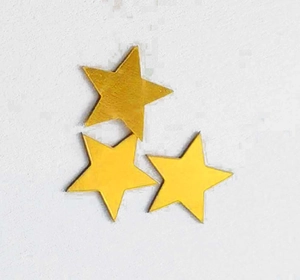 Detail of laser-cut gold hollow star decorations with matte finish texture