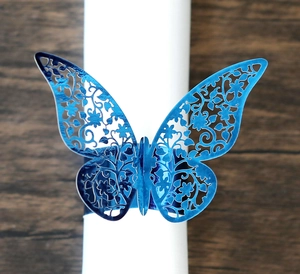 Dettaglio dell'anello portatovagliolo a farfalla blu con intaglio laser su legno