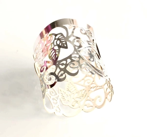 Detailed view of wide silver hollowed-out metal bracelet with floral leaf pattern