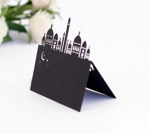 Elegant black laser-cut place card with golden mosque silhouette for Ramadan table decor