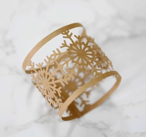 Detailed laser cut snowflake napkin ring made of kraft paper on marble surface