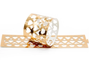 Macro detail of laser-cut gold hollow heart paper napkin rings for elegant dining decor