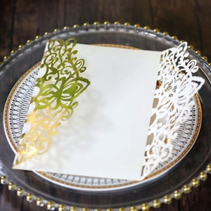 Close-up of laser-cut butterfly invitation card with gold foil accents on pearl paper