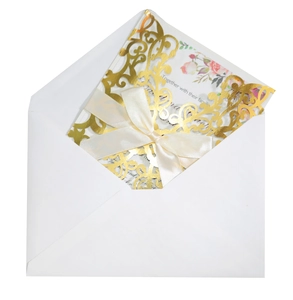 Detail of rose gold laser cut wedding invitation with ivory silk bow and floral insert