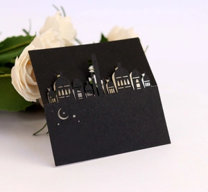 Detail of laser-cut black table card with intricate mosque and star moon silhouette