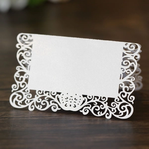 Gros plan de marque-place blanc découpé au laser pour mariage sur table en bois