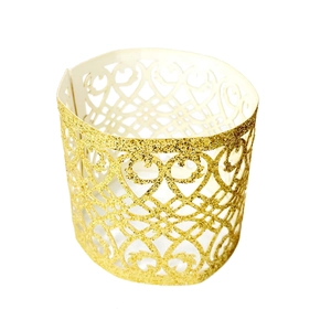 Detailed view of laser-cut gold glitter napkin ring with intricate hollow heart patterns