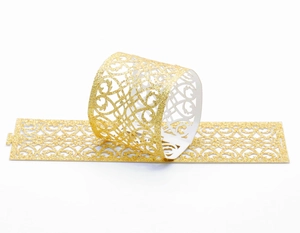 Detail of laser-cut gold glitter napkin rings featuring intricate hollow patterns