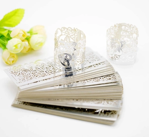 Macro detail of laser-cut white paper napkin ring with heart and floral patterns