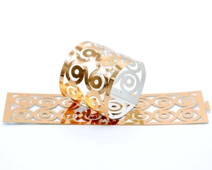 Close-up of golden hollow butterfly napkin ring with geometric laser-cut patterns