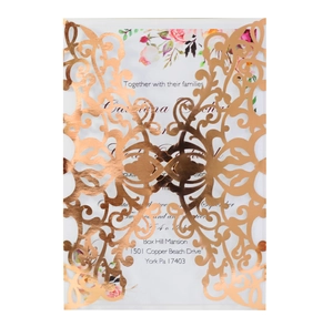 Detail of rose gold laser-cut wedding invitation with elegant floral patterns