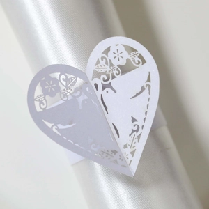 Détail du rond de serviette cœur découpé au laser avec motif d'oiseaux et de fleurs