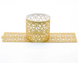 Detail of laser-cut glitter napkin ring with gold heart pattern and sparkling texture