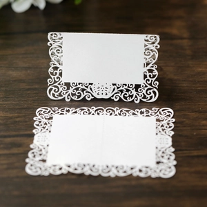 Détail du marque-place de mariage blanc découpé au laser avec motifs de vignes fins