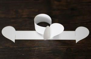 Vue rapprochée de ronds de serviette en papier blancs en forme de cœur sur fond de bois