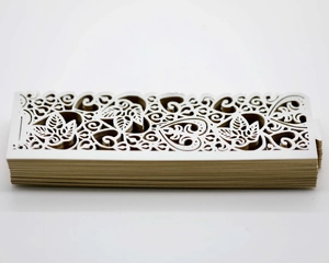 Macro detail of laser-cut cream paper lanterns featuring intricate leaf and heart patterns