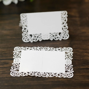 Détail d'un marque-place de mariage blanc découpé au laser avec motifs de dentelle florale
