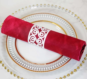 Detail of laser-cut white paper butterfly napkin ring on red satin fabric