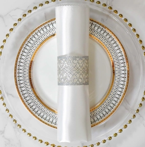 Detail of silver glitter laser-cut napkin ring with heart pattern on white marble table