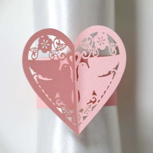 Détail du rond de serviette cœur rose découpé au laser avec motif oiseau et fleur