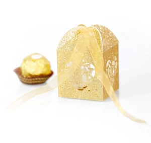 Close-up of gold glitter wedding candy box with laser-cut heart and ribbon