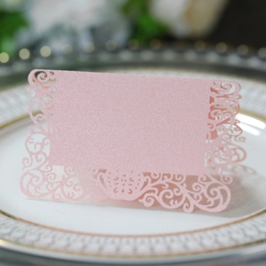 Détail de marque-places de mariage à paillettes roses découpés au laser sur porcelaine