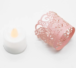 Detail of pink laser-cut glitter paper lampshade with hearts and LED candle light