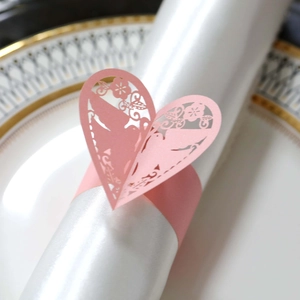 Gros plan sur le rond de serviette en forme de cœur rose avec motifs découpés