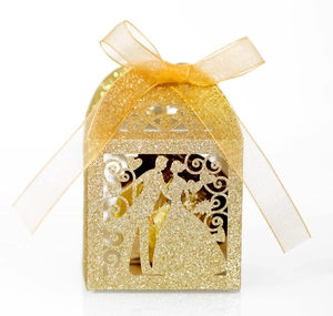 Detail of laser-cut glitter gold wedding favor box with bride and groom silhouette