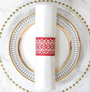 Close-up of glittery red heart napkin ring on luxury dinnerware with gold accents