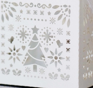 Dettaglio di una scatola regalo bianca con motivi di fiocchi di neve intagliati