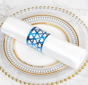 Detailed view of a blue hollow heart napkin ring on a white silk napkin on marble table