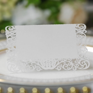 Marque-place de mariage découpé au laser avec motif floral élégant sur une assiette blanche