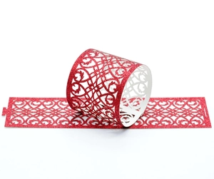 Detailed laser-cut scroll pattern on red glitter napkin ring and cupcake wrapper