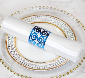 Detail of laser-cut spiral hollow napkin ring in shiny blue finish on white fabric