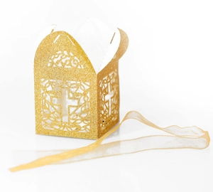 Detail of laser-cut cross and floral patterns on glittery gold wedding favor box