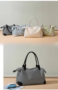 Détails des poignées en cuir renforcé et des coins de base des sacs de voyage pied-de-poule