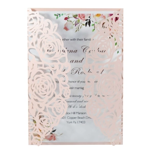 Detail of laser-cut rose hollow wedding invitation with pink cover and floral card