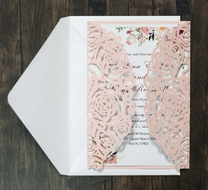 Detail of pink laser-cut rose pattern on wedding invitation with elegant floral inner sheet