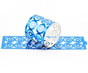 Macro detail of laser-cut metallic blue napkin rings with spiral hollow pattern