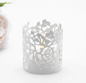 Detailed laser-cut white metal candle holder with elegant rose and leaf pattern cutout