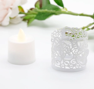 Detail of laser-cut leaf pattern on white paper lampshade with LED tea light candle