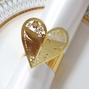 Détail du rond de serviette en cœur découpé au laser avec motifs floraux dorés pour mariages