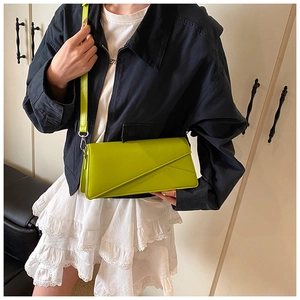 Detail of neon green leather crossbody bag featuring an asymmetric geometric flap design
